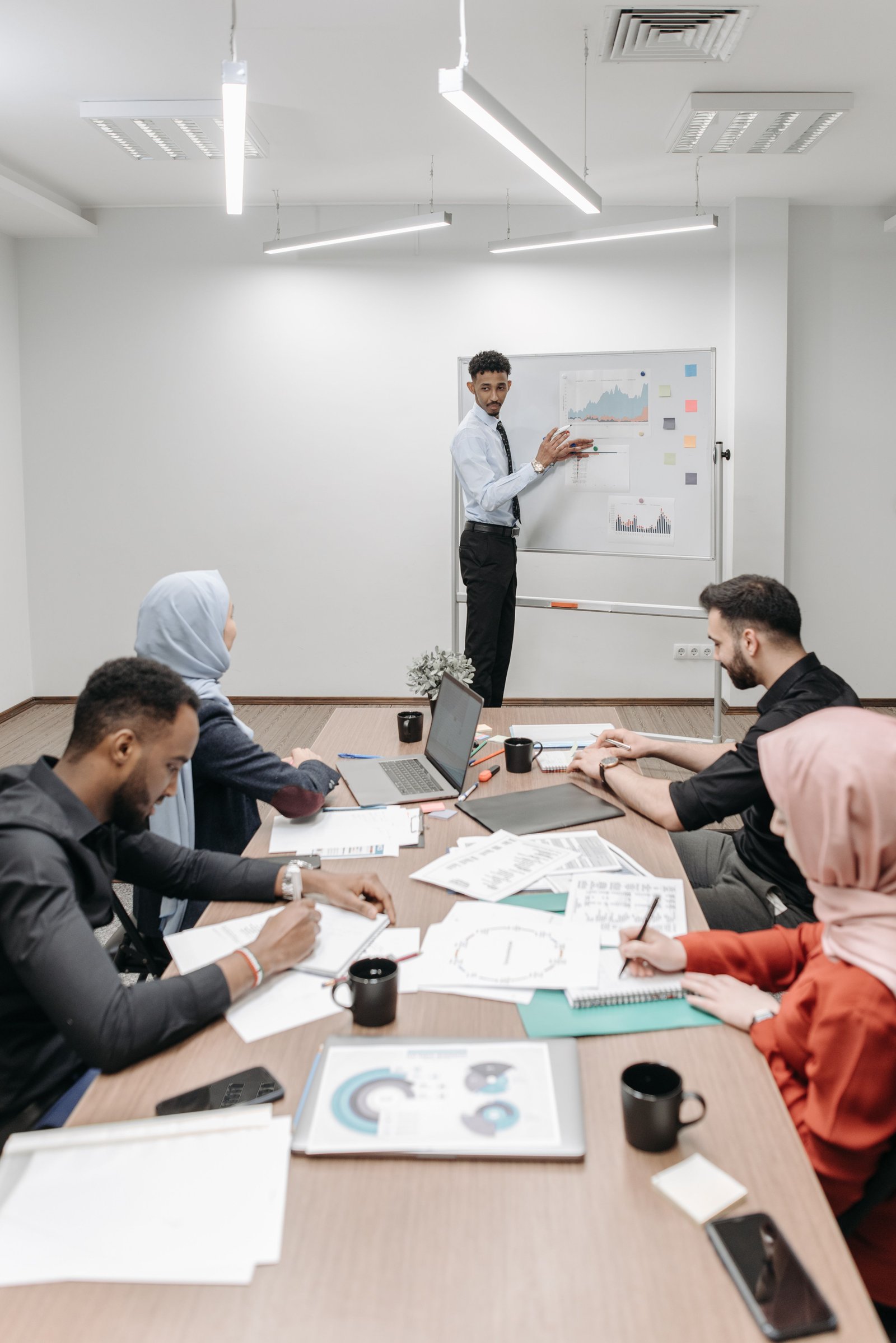 Business presenter and team working at a whiteboard